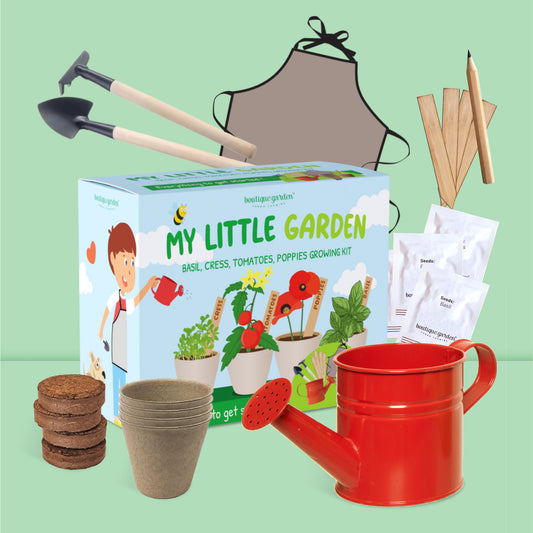Vue d'ensemble de tous les accessoires du kit jardinage enfant : pots, graines, arrosoir, tablier et substrat.